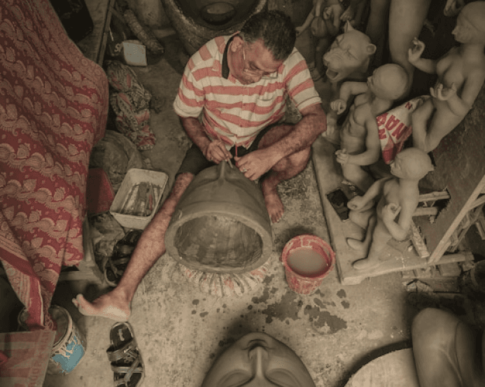 Craftsman working with handmade spiritual clay sculptures